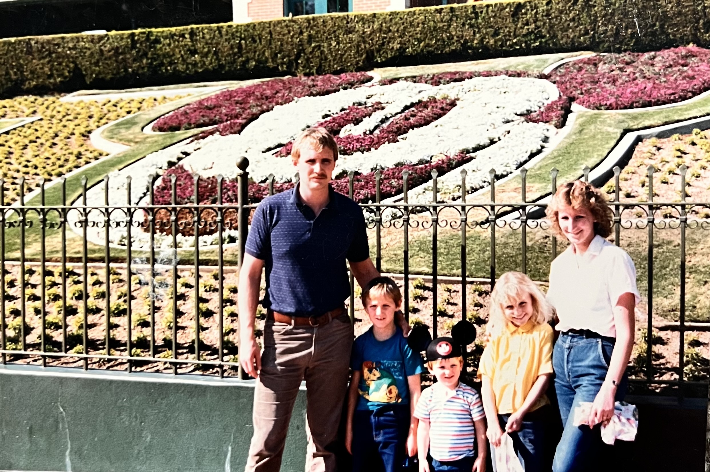 The Hirst family at Disneyland in front of the Mickey hedge.